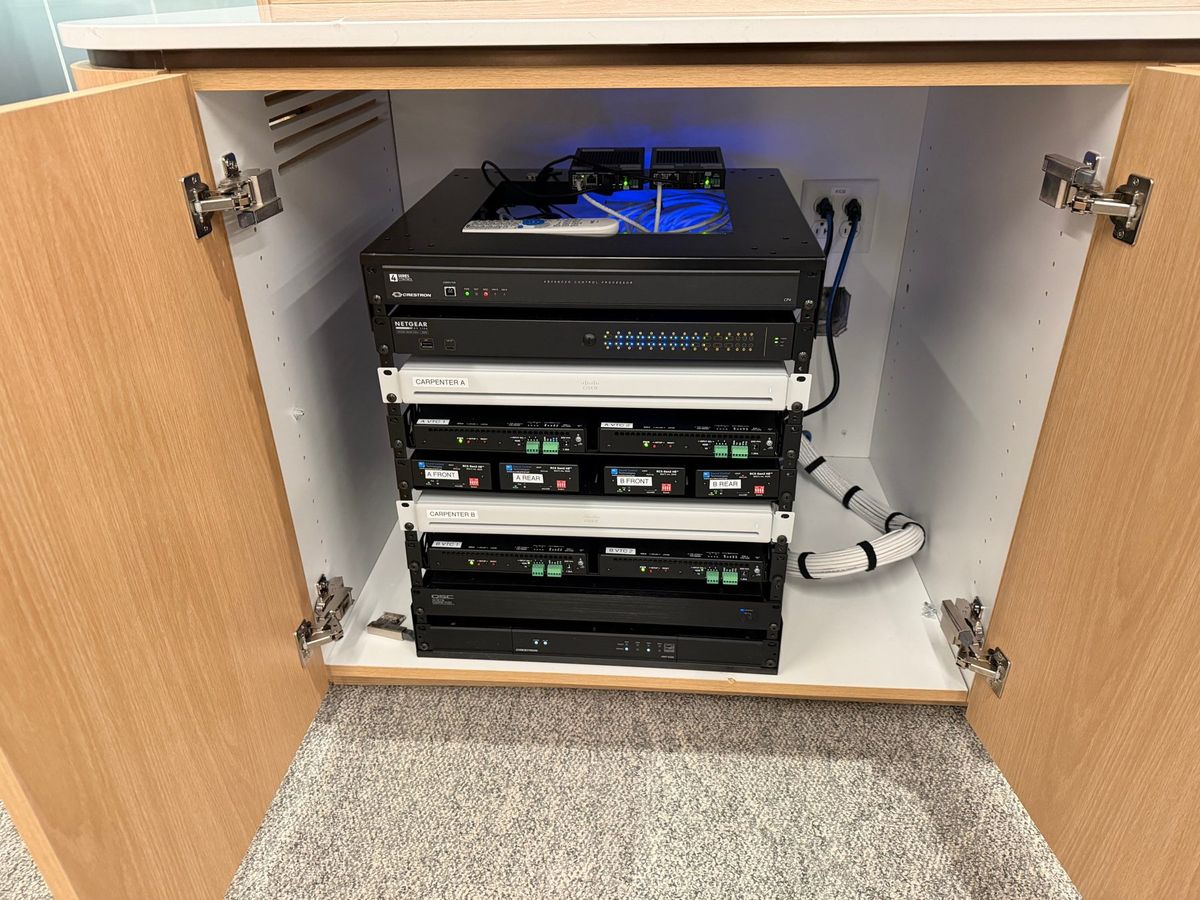 Neatly dressed equipment rack inside a credenza cabinet, installed by Enlightened Audiovisual