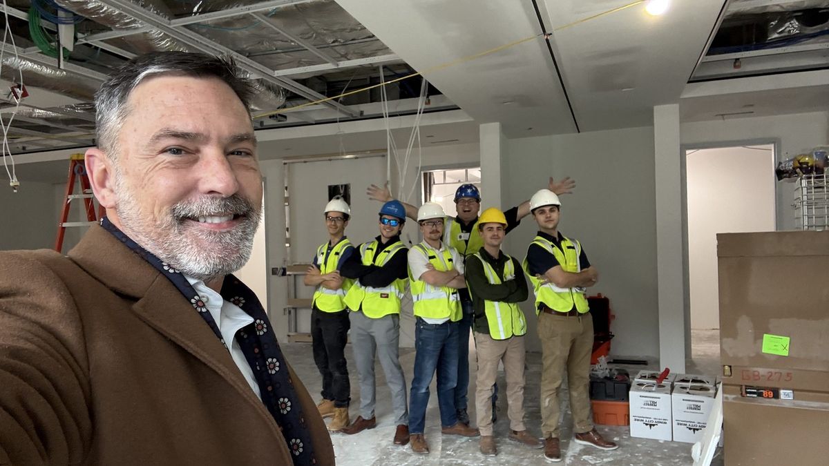 Enlightened Audiovisual crew in hard hats and safety vests on a construction job site